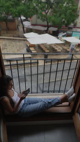 woman relaxing on a rainy day balcony