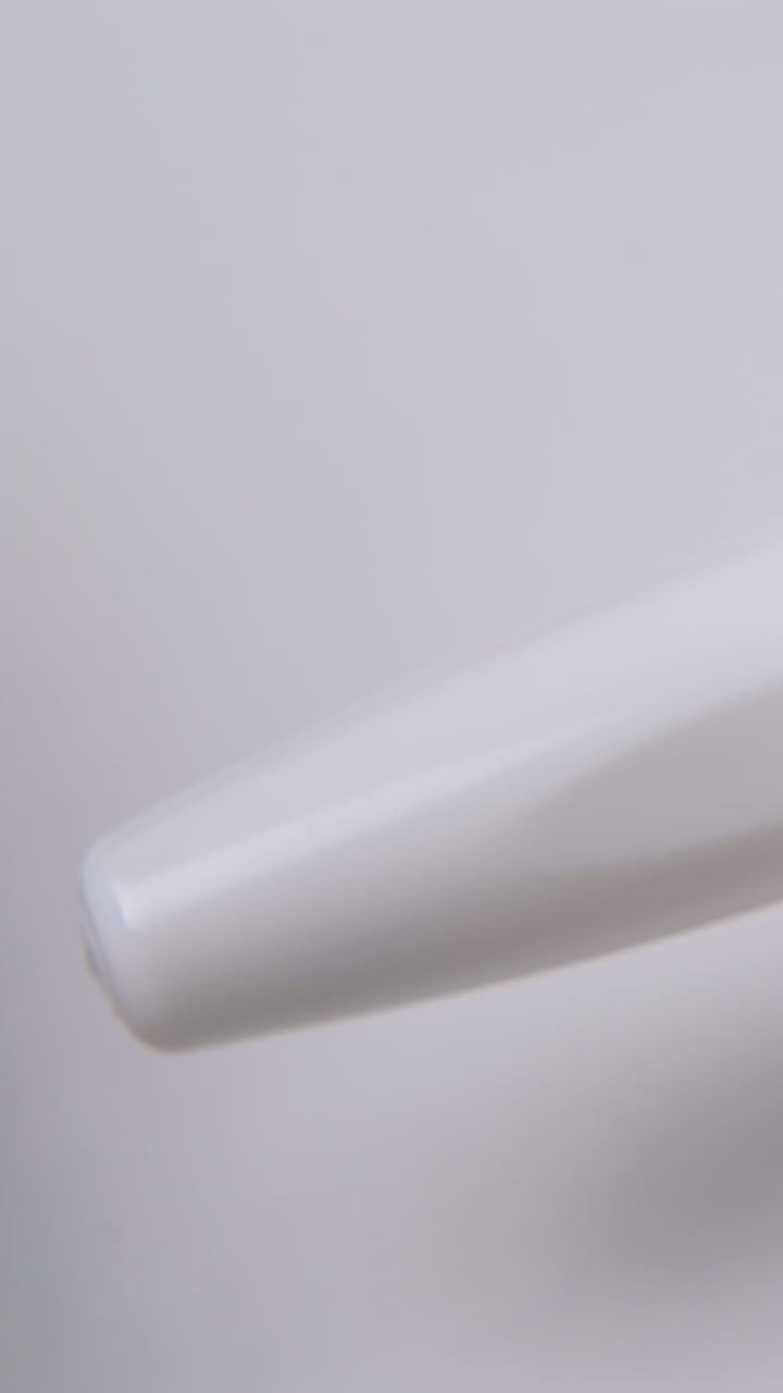 man taps on cap by fingers and opens nasal spray with white plastic cap on light background extreme close view