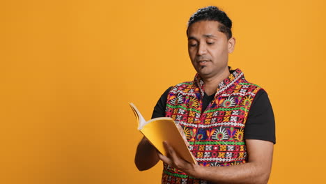 man reading book, having fun, isolated over studio background