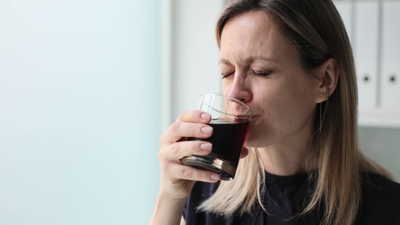 una mujer bebiendo de un vaso