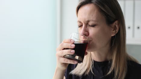 a woman drinking from a glass