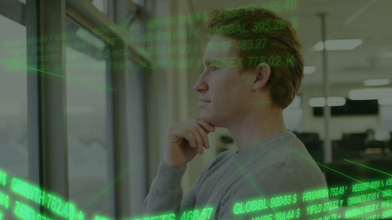 Man standing by window, holding chin, watching scrolling green ticker spurring investment decision