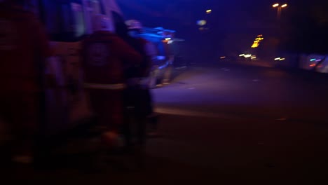 An-individual-is-escorted-to-the-ambulance-by-rescue-personnel-on-a-night-of-protest-in-Tripoli,-Lebanon