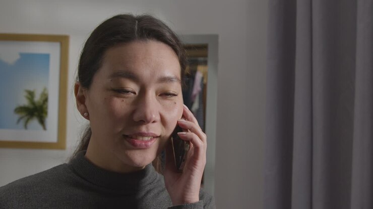 Pleased Young Woman At Home Receiving Phone Call Confirming Job Offer