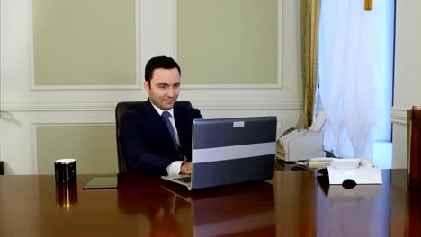 trabajador europeo escribiendo en el teclado y mirando el monitor de la computadora portátil