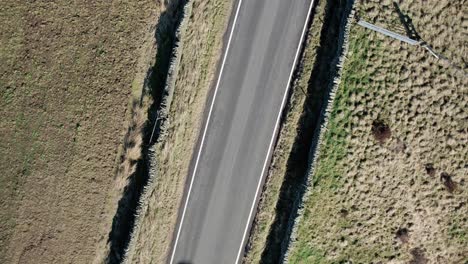 Aufnahme-Von-Oben-Nach-Unten-Eines-Autos,-Das-Auf-Einer-Landstraße-In-Derbyshire,-Großbritannien,-Durch-Den-Rahmen-Fährt