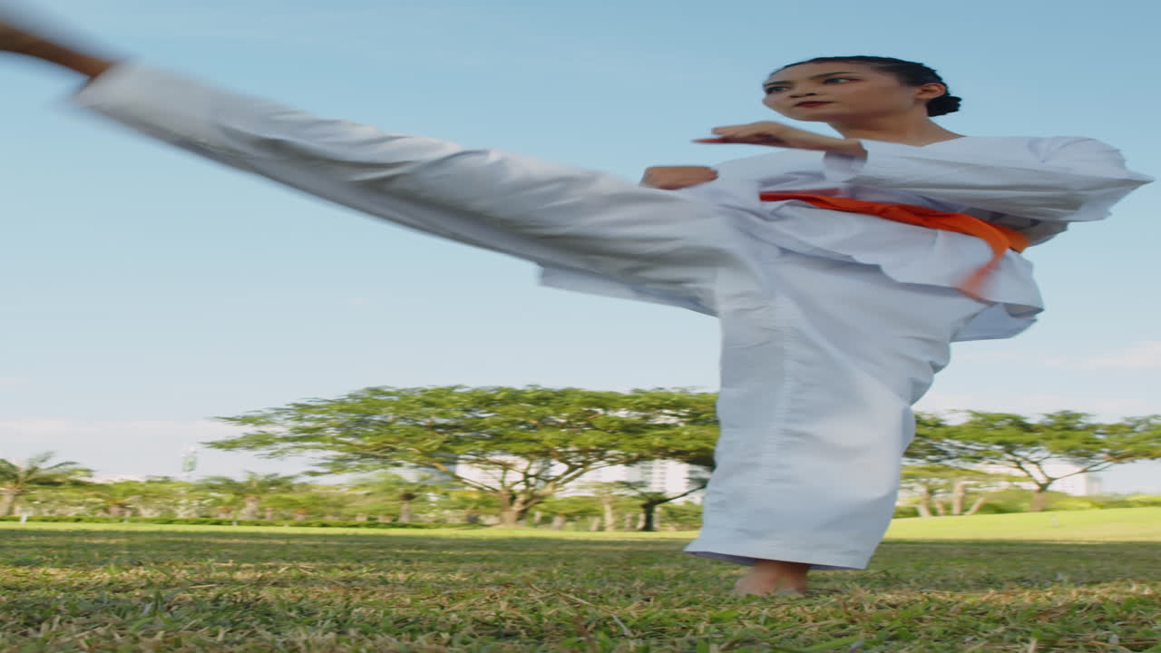 Nữ vận động viên mặc đồng phục Taekwondo tập luyện ngoài trời