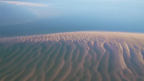 Stunning-lightly-misty-view-over-a-deserted-golden-sand-beach-with-blue-ocean