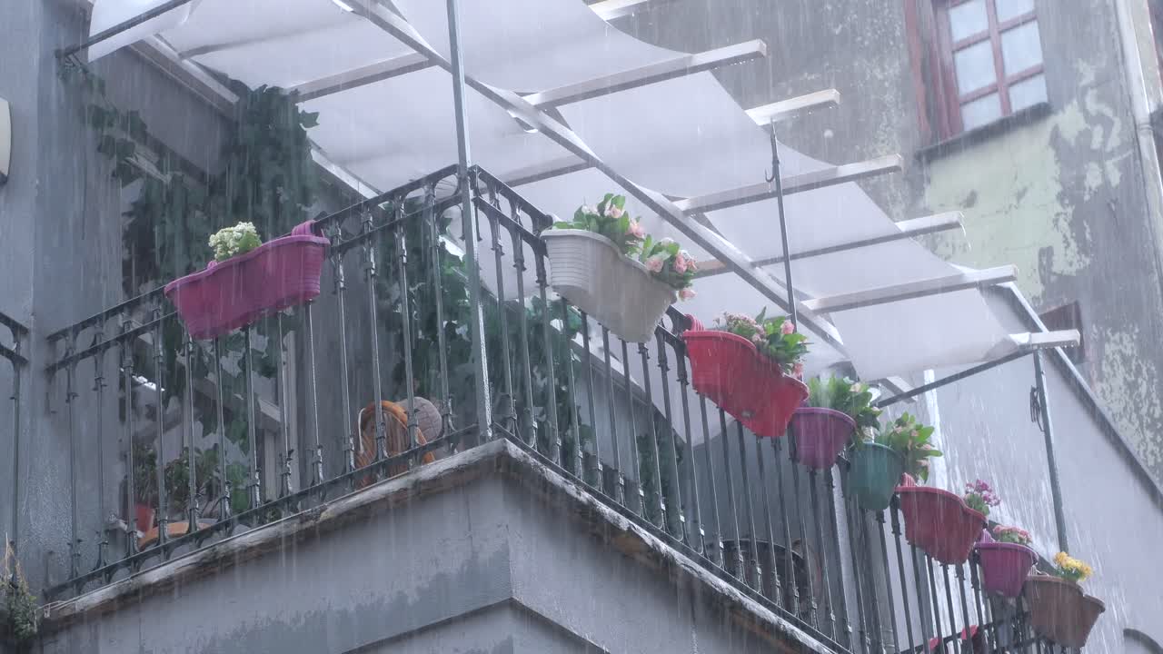 꽃이 있는 비가 오는 발코니