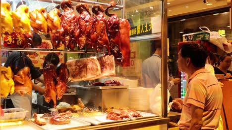 customer buying roasted meats at a food stall