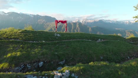 drone approaches and flies above wedding arch on top of the mountain, golden hour