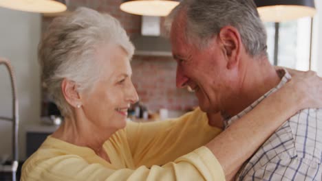 Pareja-Caucásica-Mayor-Bailando-Y-Sonriendo-En-La-Cocina