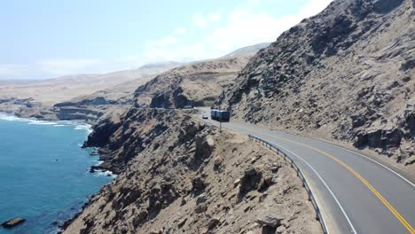 coche y camión pasando a lo largo de la carretera al lado del mar en un hermoso paisaje y puesta de sol