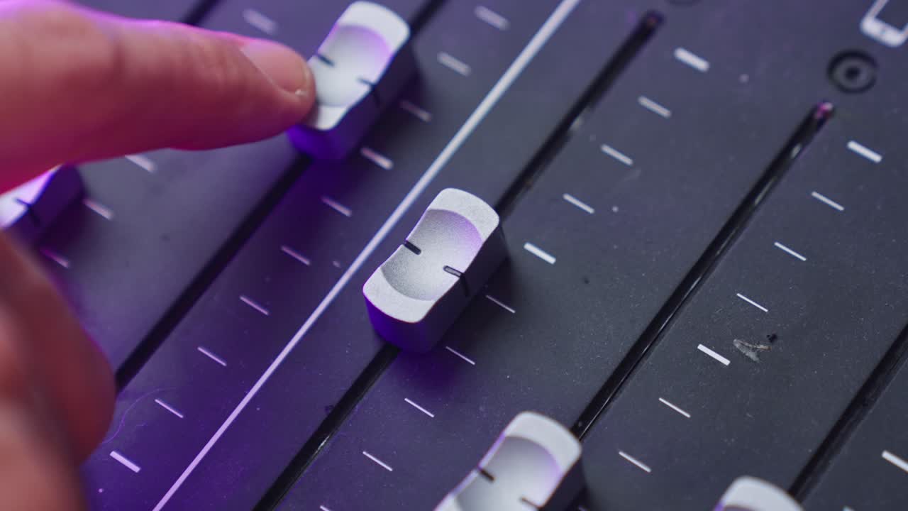 cerca de la mano moviendo fader de audio o deslizador en la placa de sonido o consola de mezclador en el estudio de grabación de sonido. ingeniero o técnico profesional jugando con los niveles de volumen en la producción de música o podcast