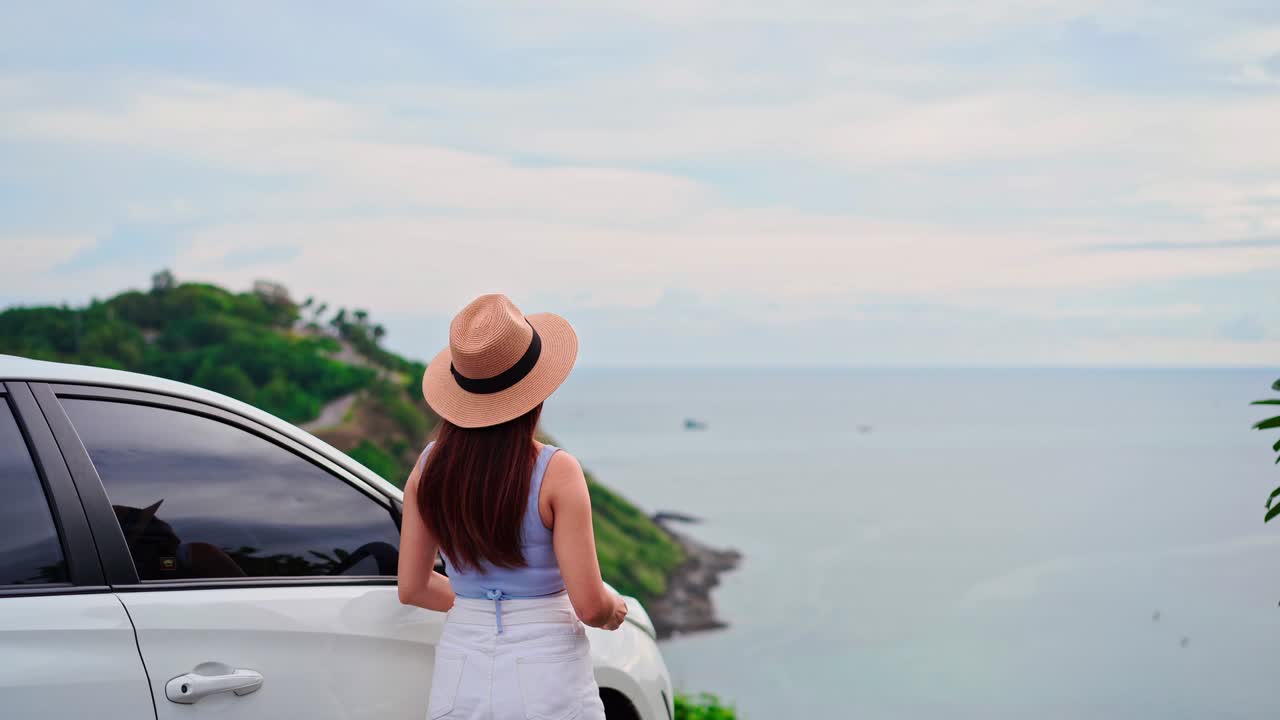 joven viajera mirando y tomando una foto con la hermosa vista del mar con su coche mientras viaja conduciendo un viaje por carretera en vacaciones