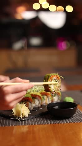 sushi roll being eaten with chopsticks