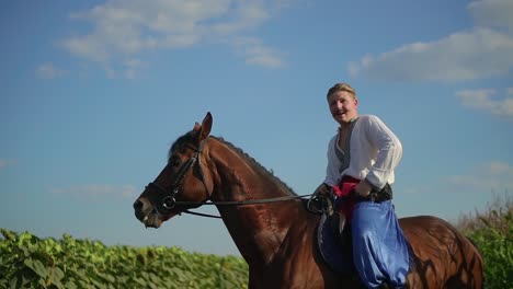 ukrainian cossack riding a horse in the field looks far 07