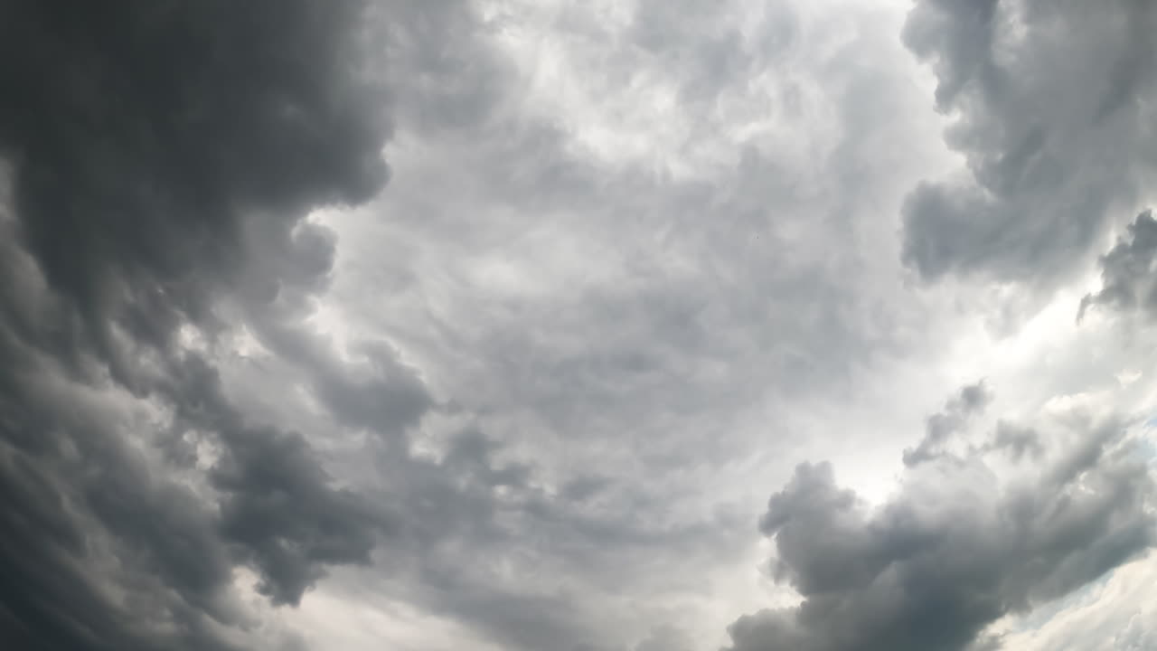 Dramatic gray skies with heavy clouds. Rainy cloudscape accumulating in the atmosphere. Low angle view. Timelapse.