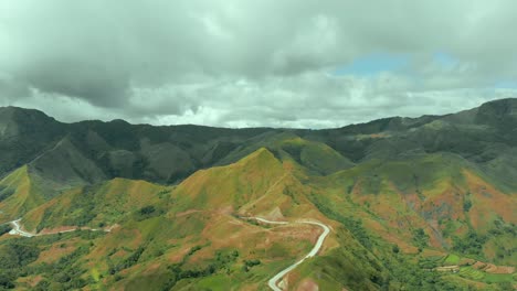 Vista-Aérea-De-Carreteras-Con-Altas-Montañas-A-Un-Lado-En-Un-área-Remota-De-Campo-Traviesa