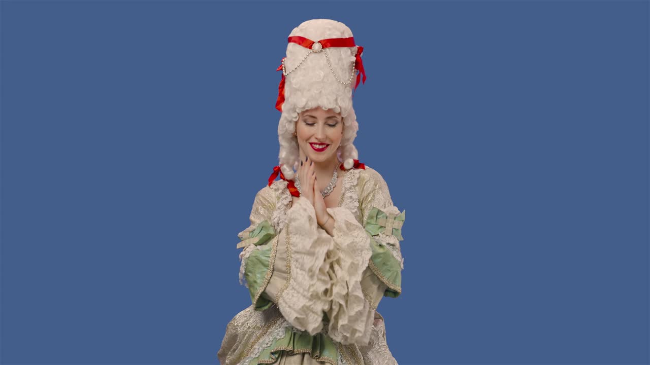 빈티지 드레스와 위그를 입고 카메라를 바라보는 궁정의 여자의 초상화: 푸른 스크린 배경으로 스튜디오에서 포즈를 취하는 젊은 여성 59.94fps