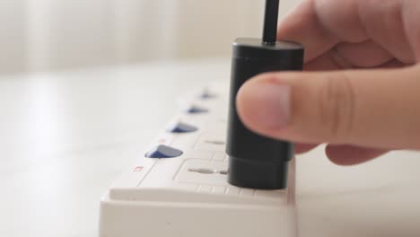 mano de hombre enchufando el cargador de batería del adaptador de teléfono para usar un teléfono móvil