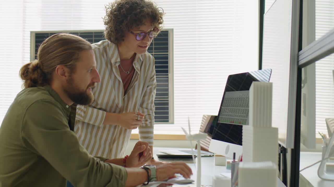 Renewable Energy Engineers Discussing Project on Computer