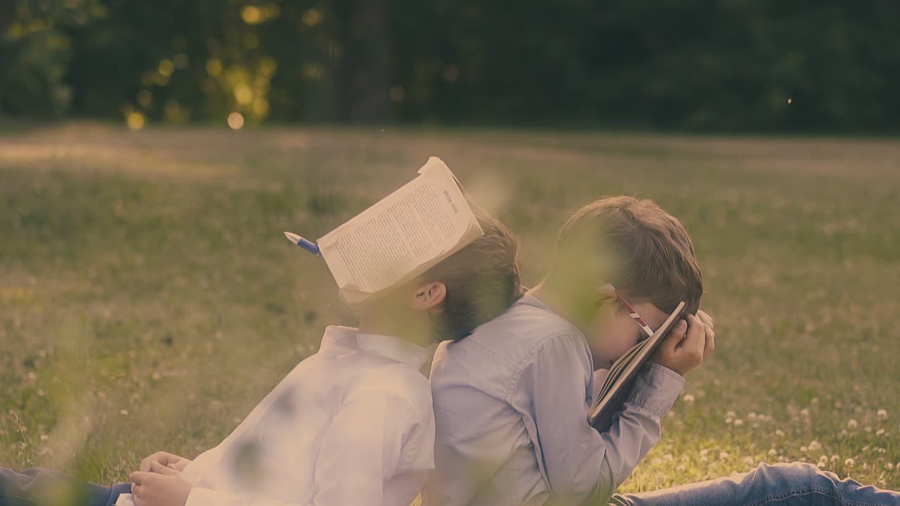 셔츠 를 입은 학교 소년 들 은 교과서 와 작업 책 을 얼굴 에 들고 있다