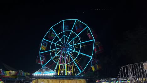 colorful ferris wheel glowing with neon lights spins at night in a festive carnival scene, perfect for travel, lifestyle, and event-related projects