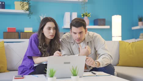 los amantes felices se regocijan. los jóvenes amantes reciben buenas noticias en la computadora portátil en casa.