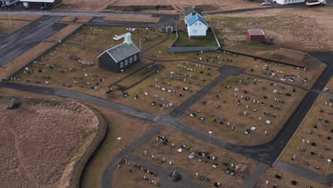 Innri-NjarÃ°vÃ­kurkirkja-church-and-cemetry-with-gravestones,-aerial