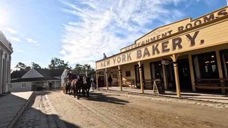 horse-drawn carriage moves past new york bakery