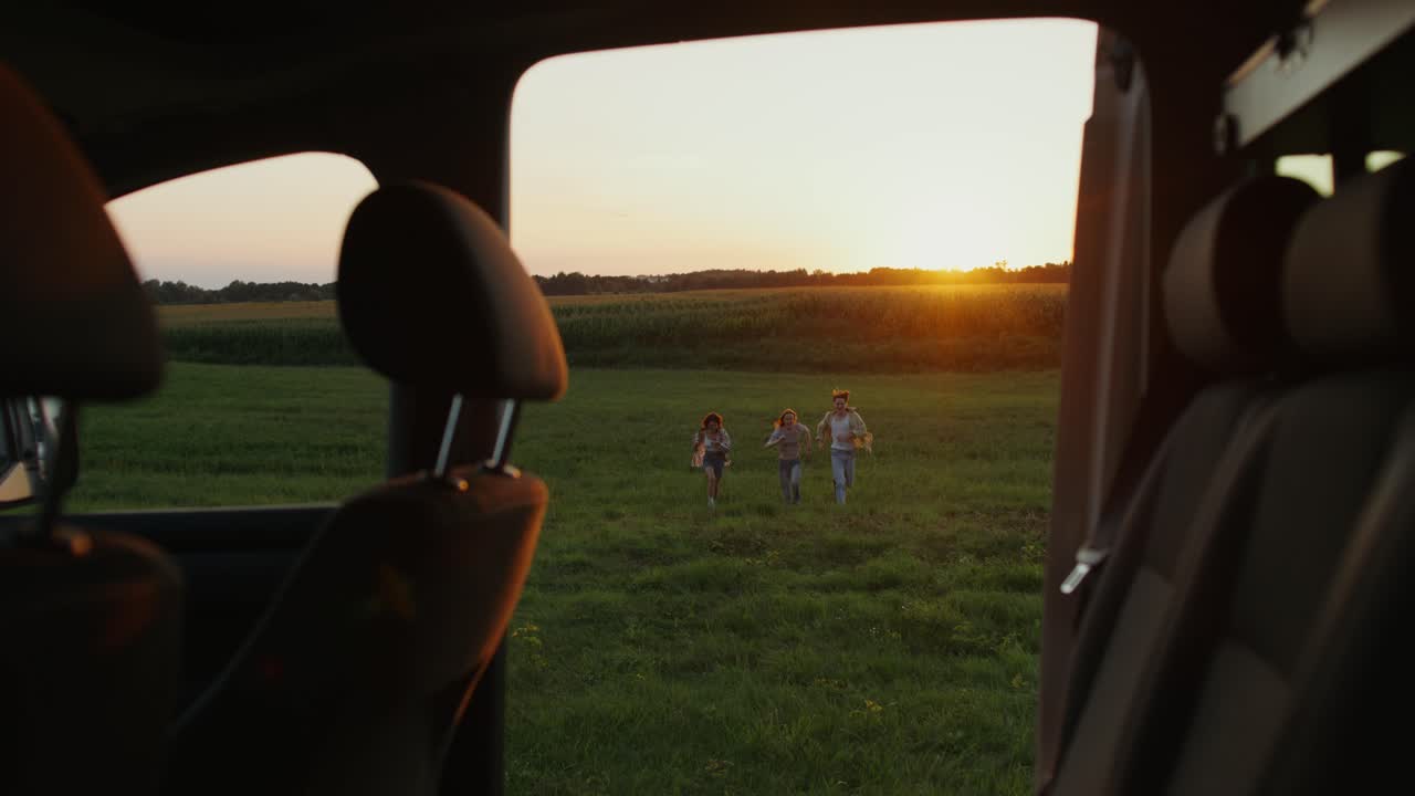 해가 지는 동안 들판에서 달리는 친구들