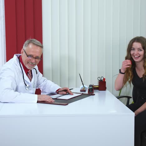 male doctor speaks with patient in office. selective focus on senior male medic at table in scrubs and phonendoscope on neck. physician at work