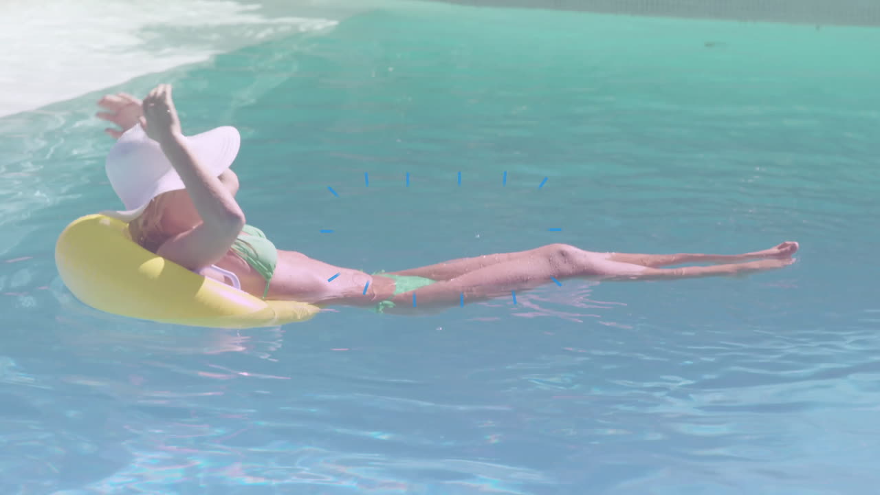 Relaxing on yellow float in pool, woman wearing hat and sunglasses
