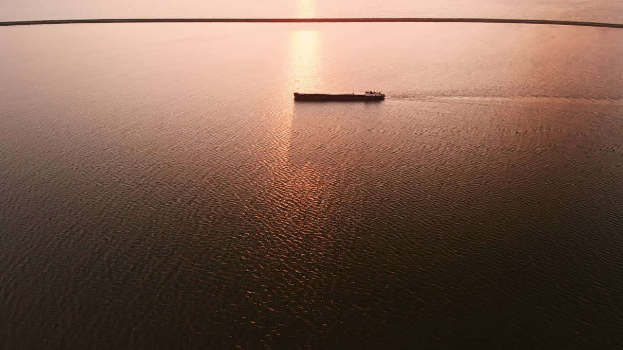 Ship In Silhouette Over The Calm Sea In Lelystad, Flevoland, Netherlands On A Glorious Sunset - aerial drone