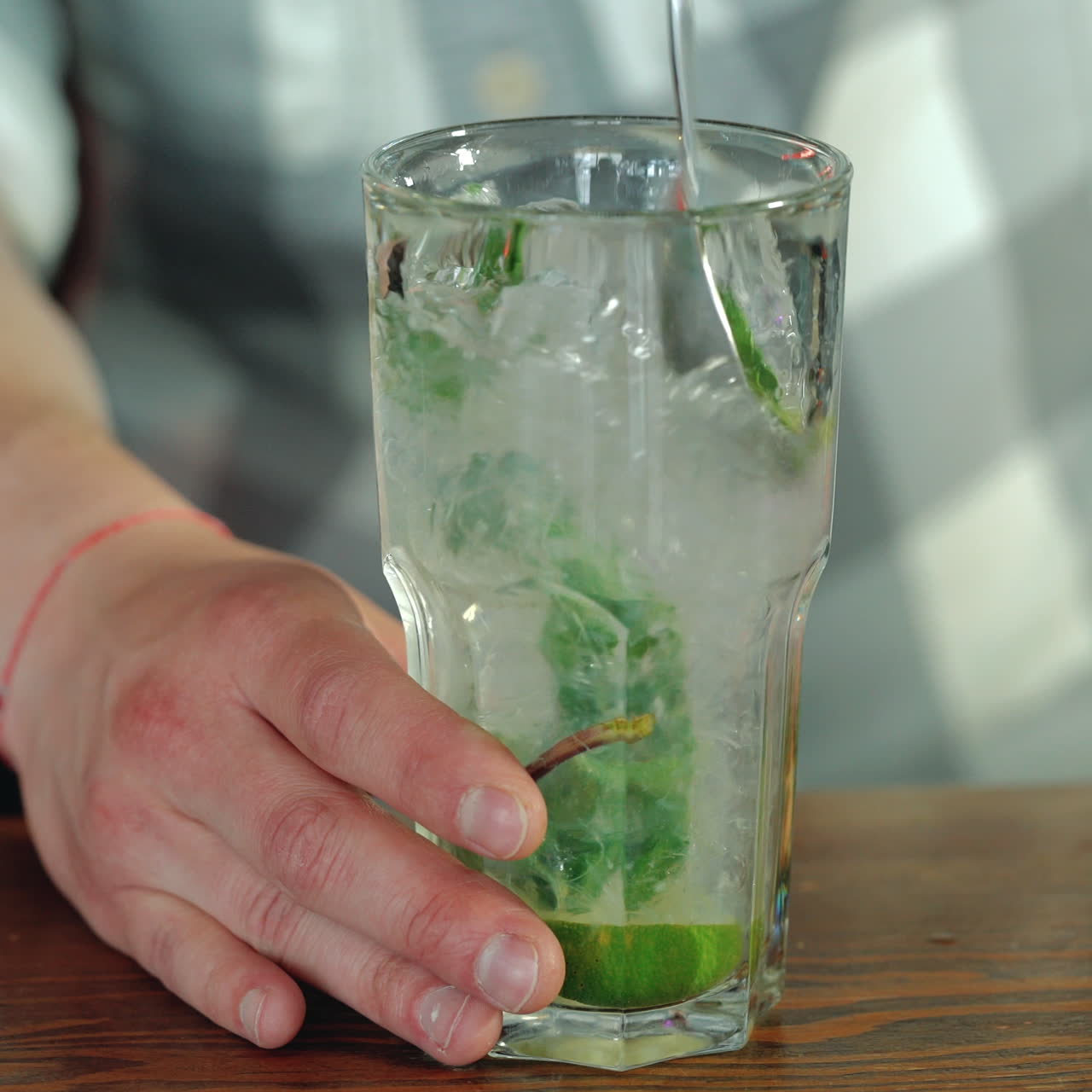 Process of preparing a cocktail. Mojito cocktail with lemon and mint on the bar. Close-up Sqare video