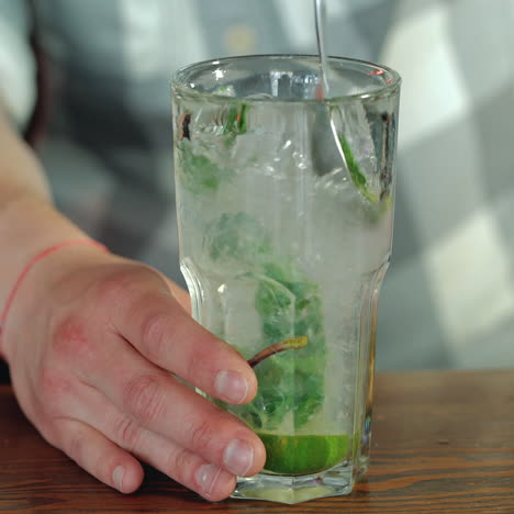 process of preparing a cocktail. mojito cocktail with lemon and mint on the bar. close-up sqare video