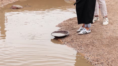 people panning for gold in muddy water