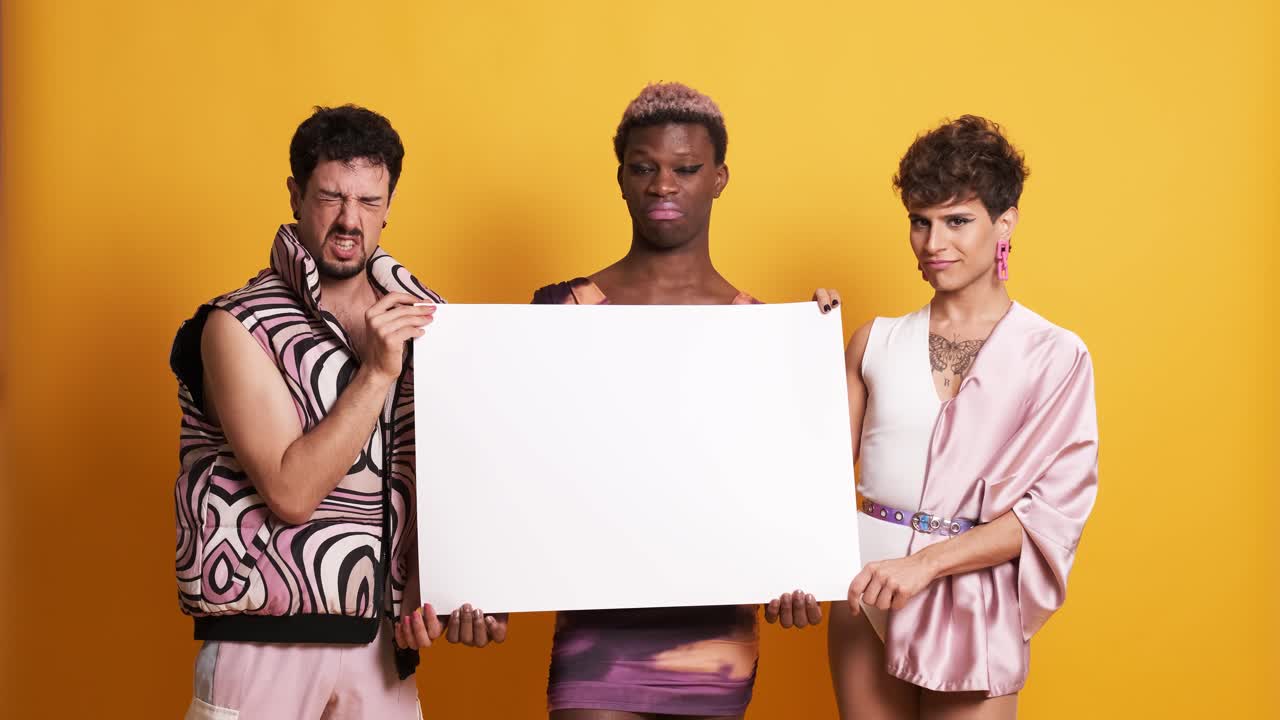 Three trans men holding a white panel with a disapproving face