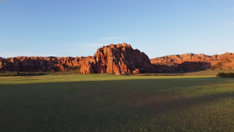 Beautiful-drone-shot-flying-over-a-desert-in-Utah-with-mountain-rocks