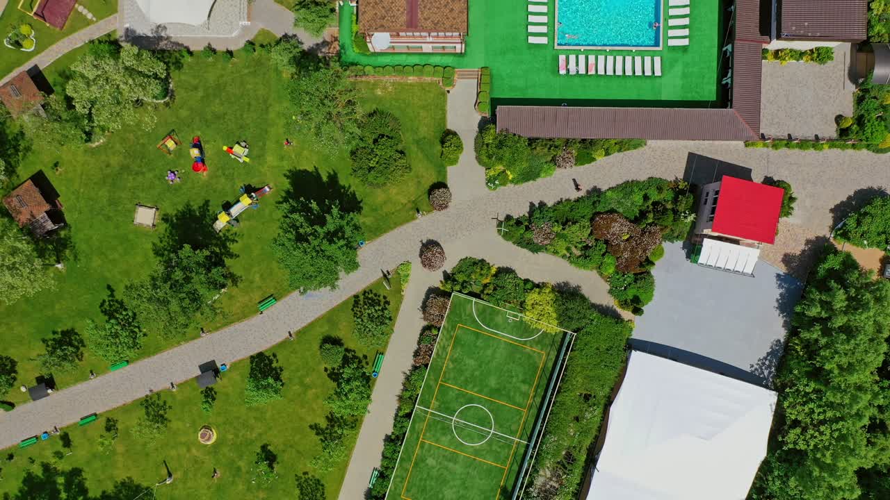 Green parks and playgrounds in recreation area. Modern resort area among nature in summer. Vacation center. Drone flight.