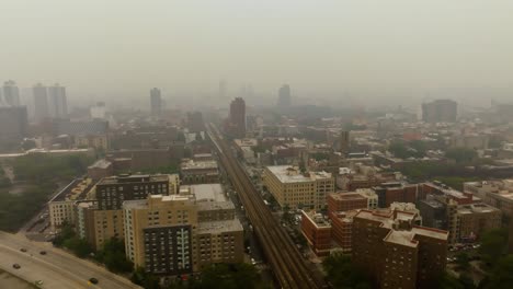 aerial view over trains in harlem, wildfire smog in manhattan, new york city, usa