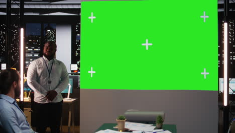 black male supervisor hosting a late meeting with chroma key display