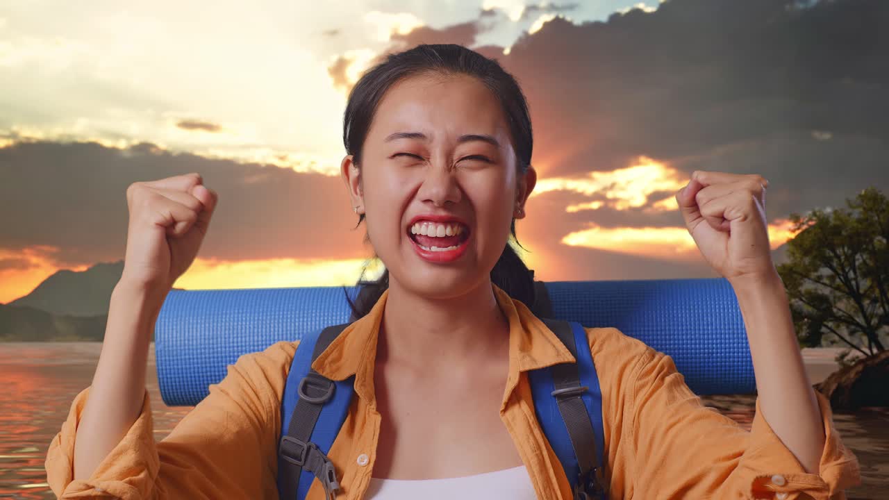Close Up Of Asian Female Hiker With Mountaineering Backpack Screaming Goal Celebrating The Success While Standing At A Lake During Sunset Time