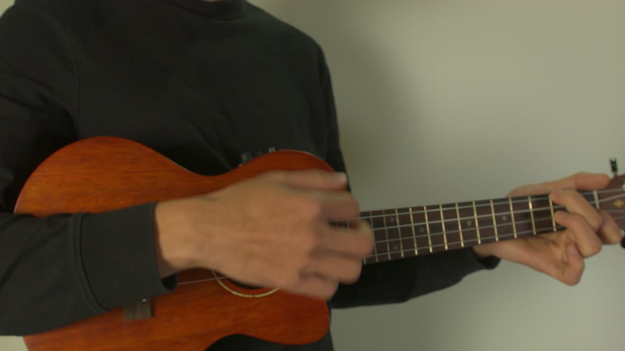 un hombre toca un ukelele con un sentimiento