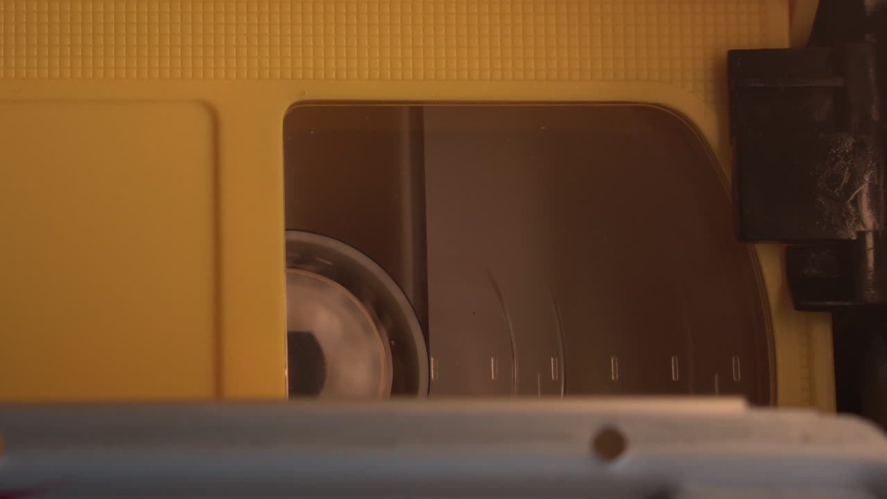 VHS Videocassette Tape Reel Spinning in Vintage 1980's Player, Close Up