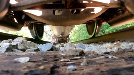 POV-Unter-Dem-Fahrenden-Zug-Auf-Den-Bahngleisen,-Güterzug,-Der-Tagsüber-Auf-Den-Bahngleisen-Fährt