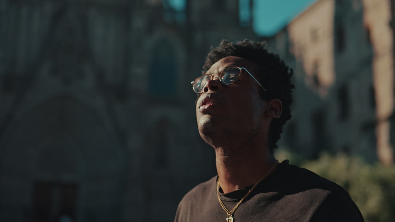 Young African American Man Looking Up at City Architecture