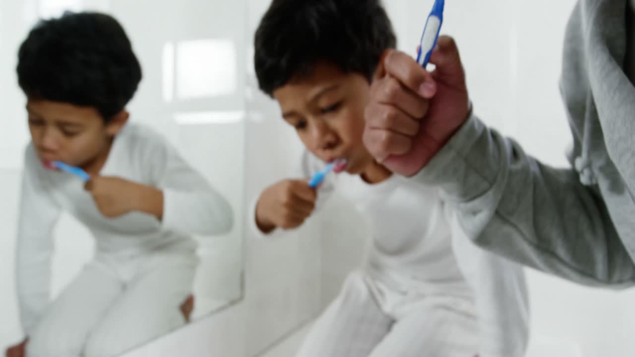 Father and son brushing teeth in the bathroom