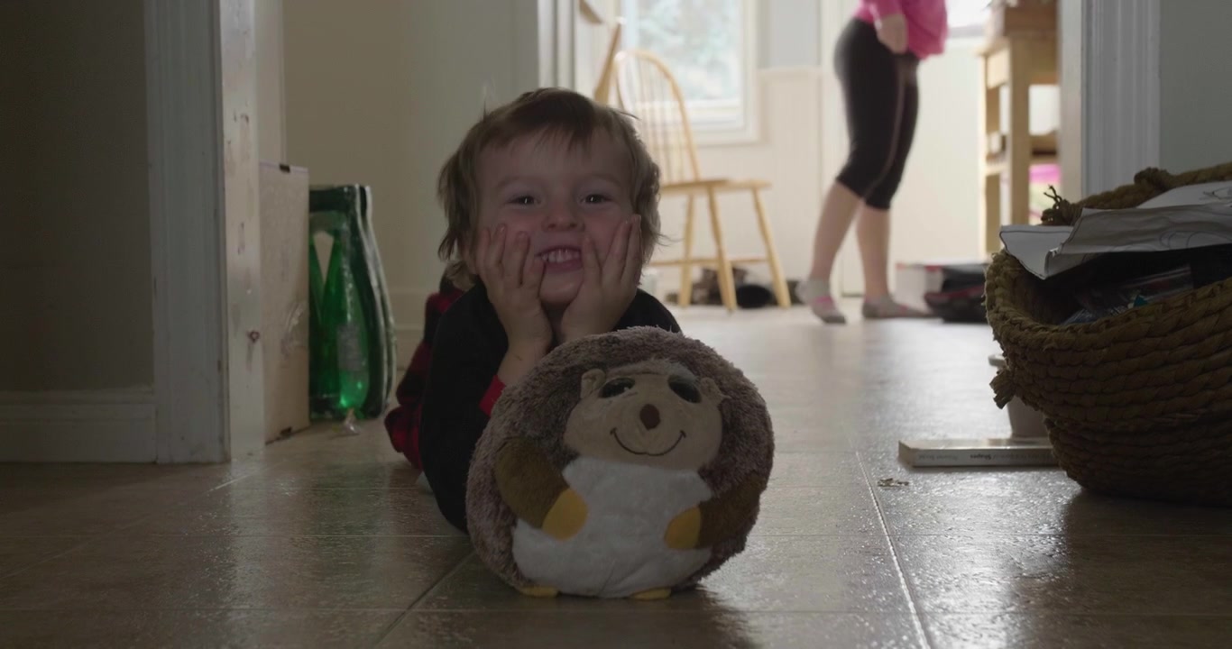 Kid playing peak a boo behind stuffed toy